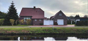 Wohnglück am Kanal: Saniertes Wohnhaus mit vielseitigem Garagengebäude und Wintergarten