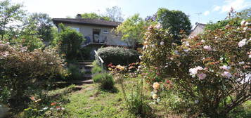 Maison sur garage de 1972 avec un grand jardin traversé par une rivière