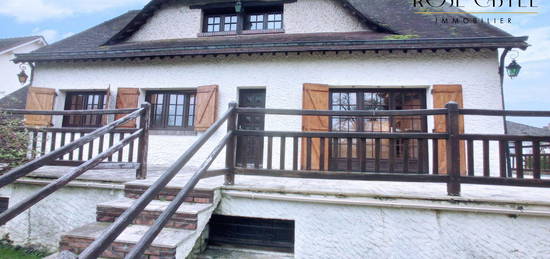 Maison traditionnelle avec jardin, sous-sol et garage.