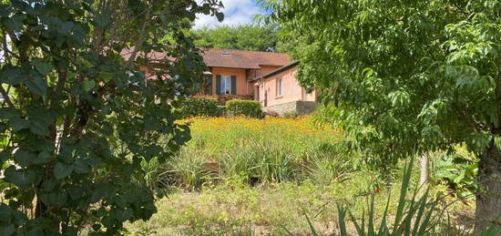 Position dominante pour cette maison offrant un plain pied et terrain en partie délimité par un ruisseau